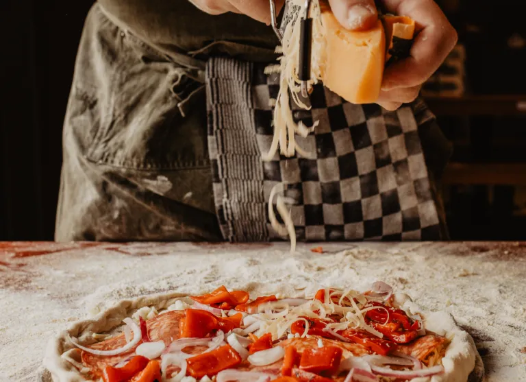 Camping de kleine wolf faciliteit schaapskooi pizza bereiden raspen kaas